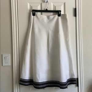 White linen skirt with embroidery at hemline.